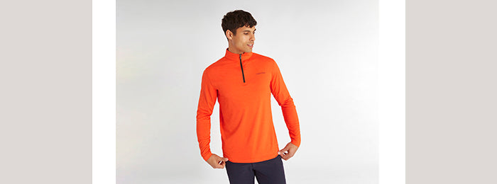 Model wearing men's orange Calvin Klein golf long sleeve golf top
