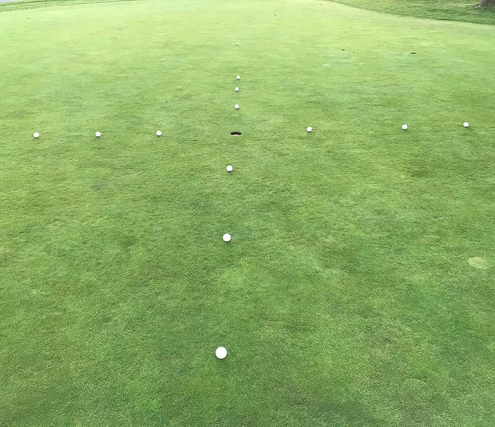 12 balls set up at varying distances from the hole to practice putting