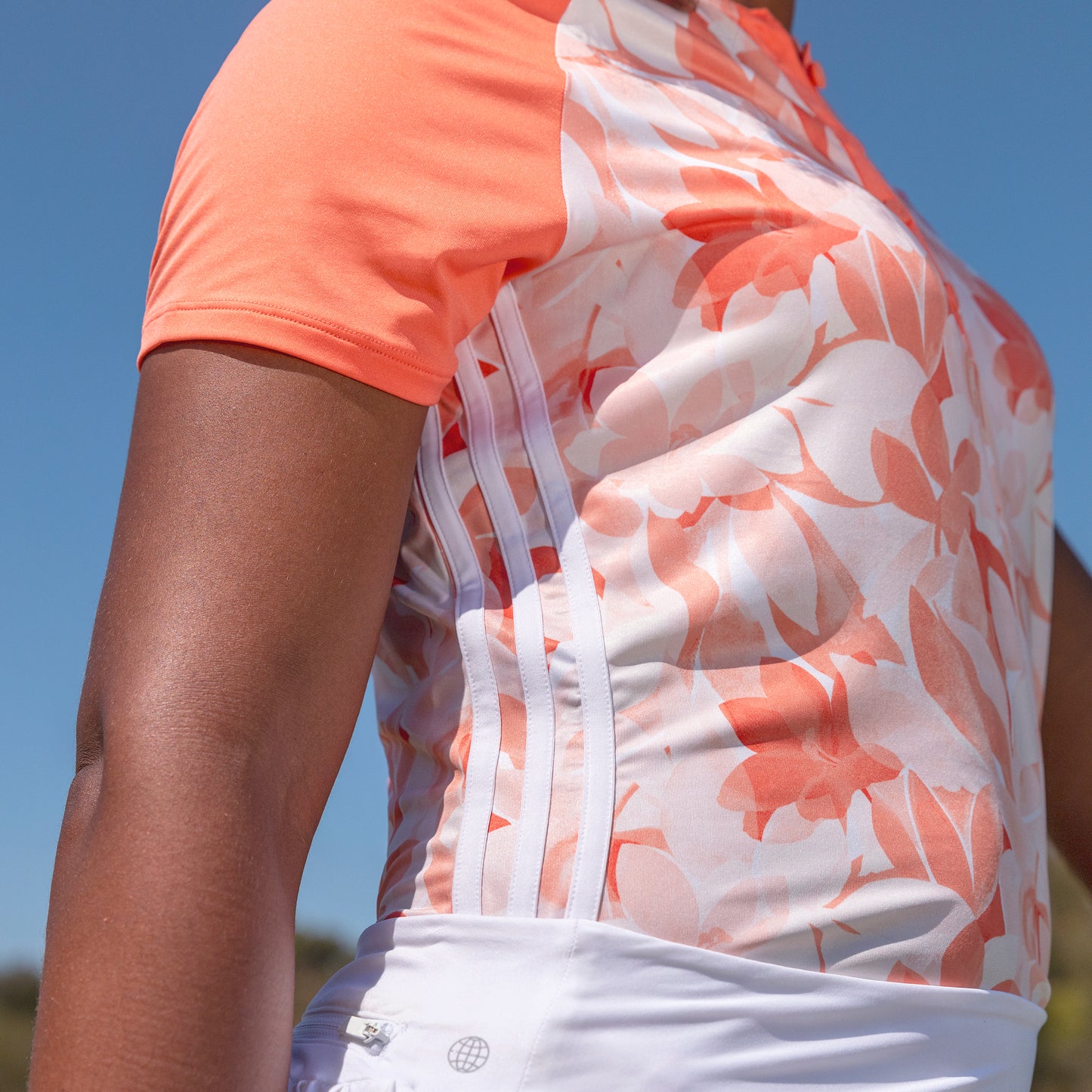 adidas Ladies Floral Short Sleeve Golf Polo with 3-Stripes Design in Coral Fusion