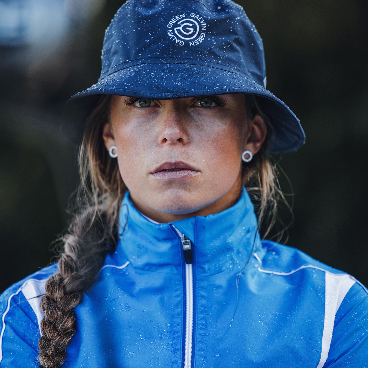 Golfer in a Galvin Green navy bucket hat and blue and white waterproof jacket from GolfGarb
