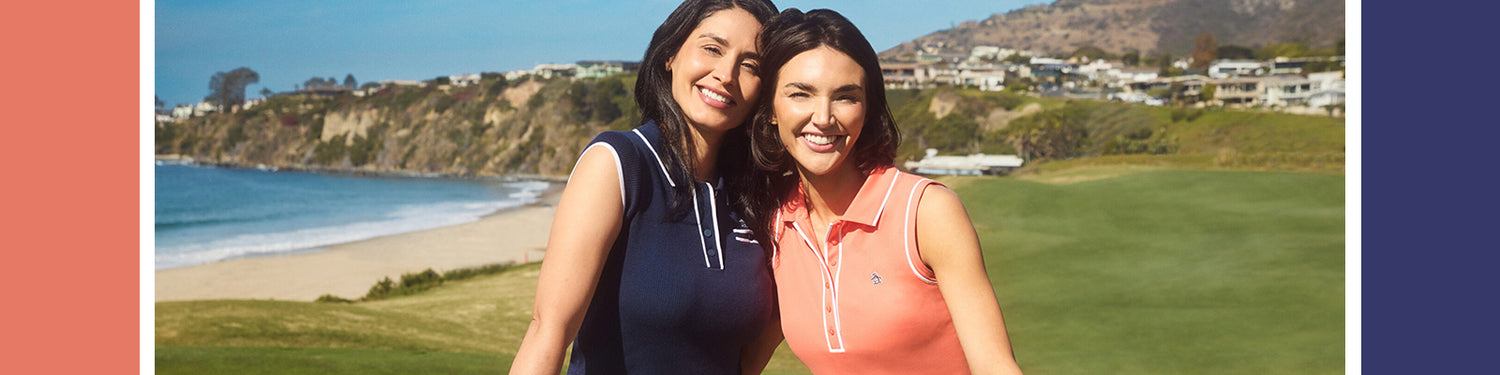 Two ladies on a links course in sleeveless golf polos with white piping trim from Original Penguin at GolfGarb