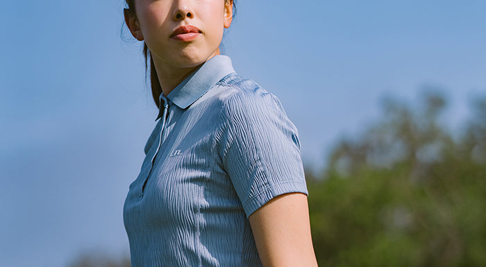 Cropped image focussing on the sleeve of a model wearing J.Lindeberg textured powder blue short sleeve polo