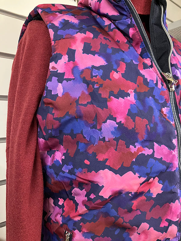 Pure Golf ladies reversible gilet with abstract brushstroke print over a burgundy roll neck top at the GolfGarb concession at Tony Valentine Golf Centre