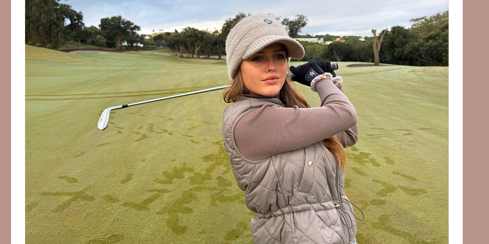 Woman on a golf course holding a golf club in Swing out Sister autumn winter collection