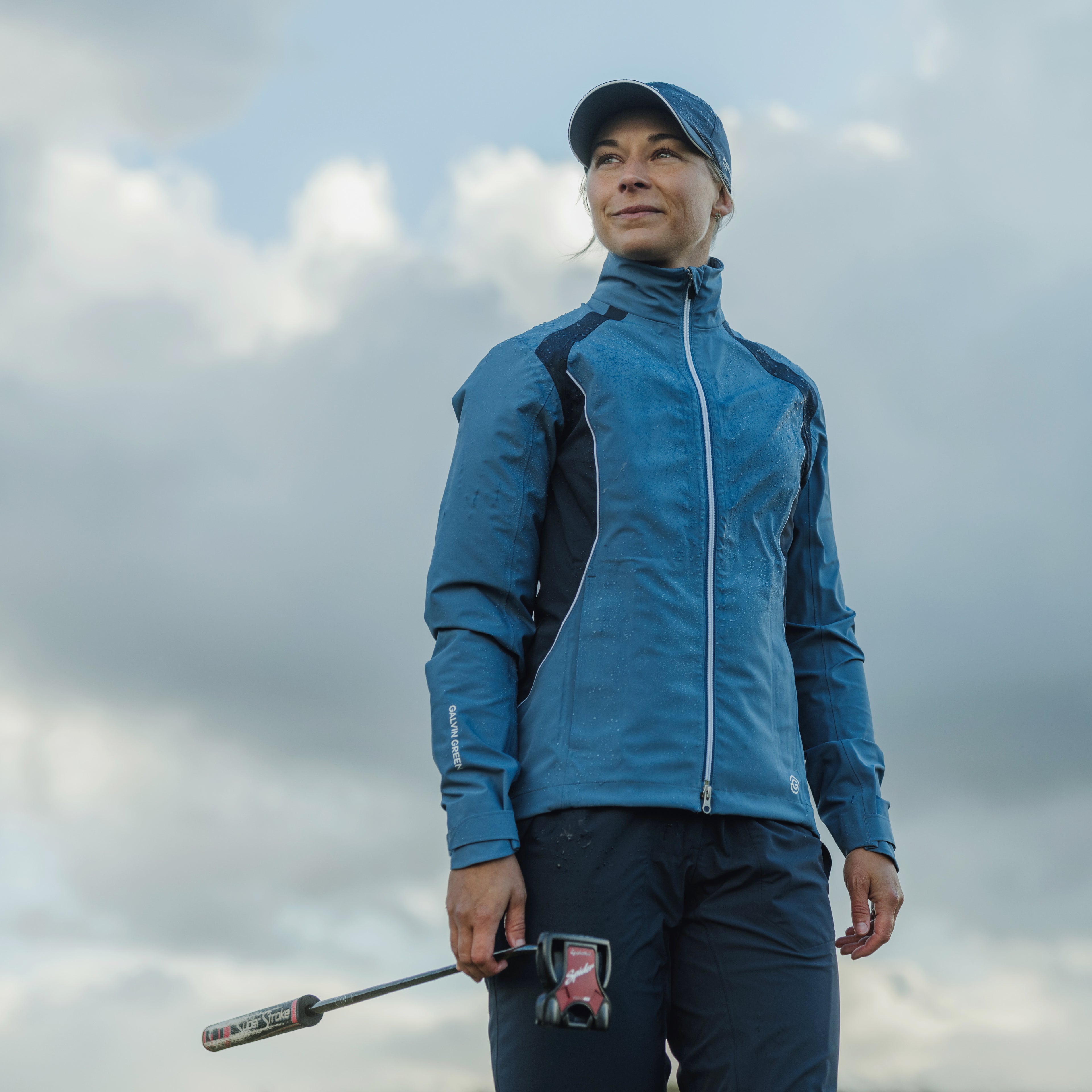 woman golfer wearing Galvin green blue waterproof jacket with pertex